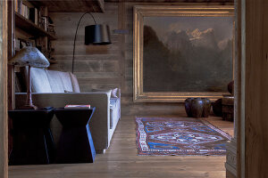 Offener Kamin an holzverkleideter Wand mit rustikalem Holzbalken als