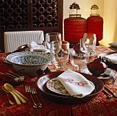Chinese tableware with bowls and red Chinese lanterns on a table with a patterned tablecloth