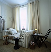 An upholstered daybed sits beneath the window in the dressing room