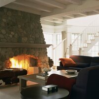 Ein rustikaler Steinkamin bildet das Herzstück des klassisch möblierten