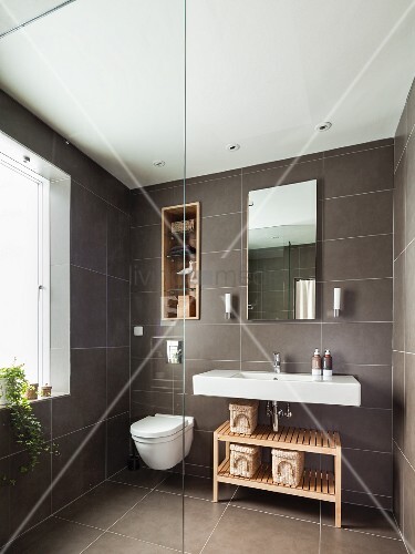 Grau gefliestes Bad mit eingebautem Regal in Wandnische über WC, neben