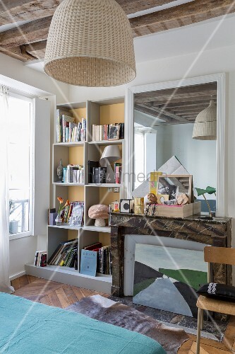 Stillgelegter Kamin mit gerahmtem Spiegel und Wandregal im Schlafzimmer