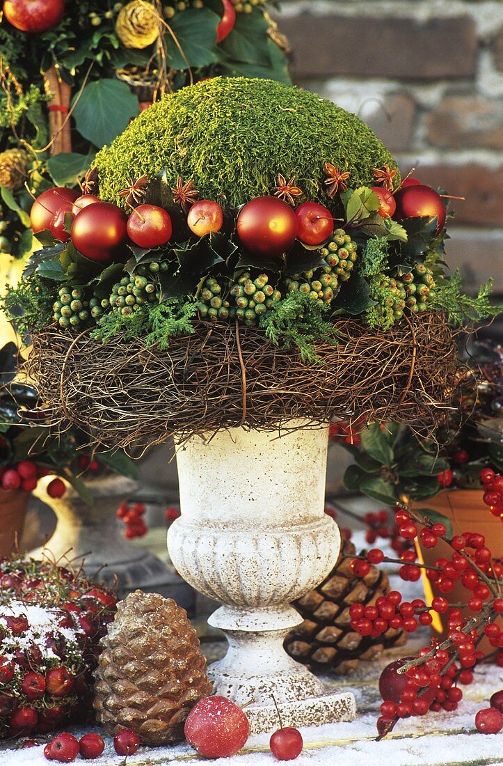 Weihnachtliches Gesteck aus Moos, Äpfeln und Efeu