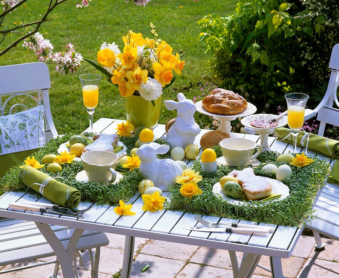 Cress, narcissi, bread plait, baked Easter Bunnies on Easter table