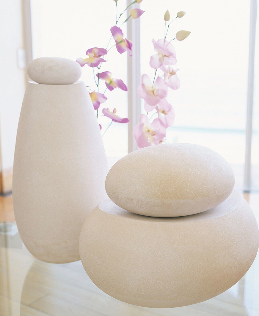 Large, smooth stones and orchids in front of window