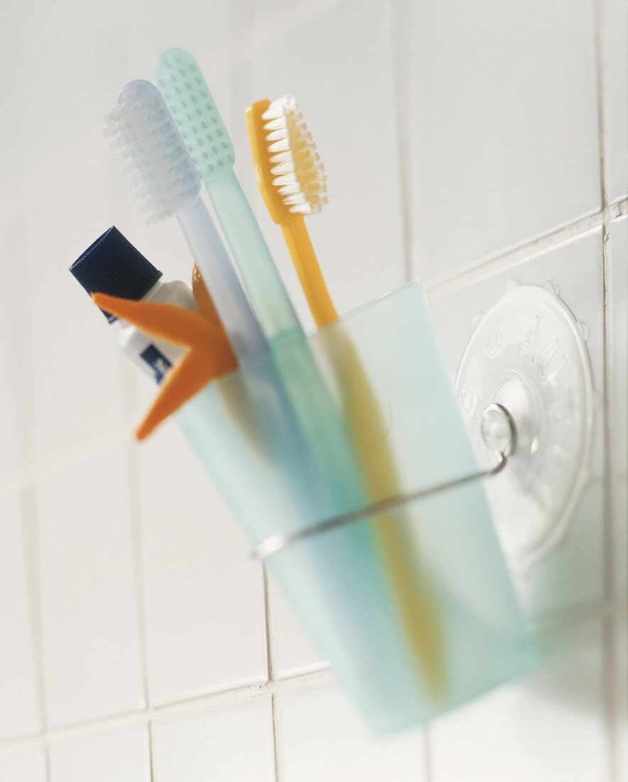 Toothbrushes and toothpaste in beaker