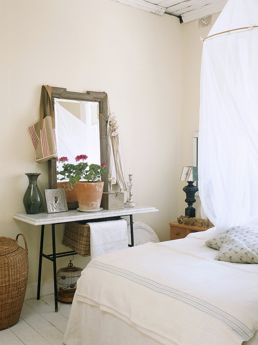 Blick in ein Schlafzimmer mit Kosmetiktisch und Topfpflanze