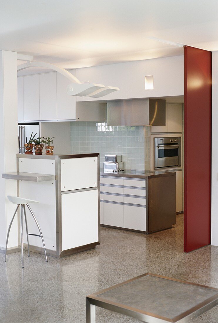 Eine Küche mit roter Schiebetrennwand und Edelstahlarbeitsplatte