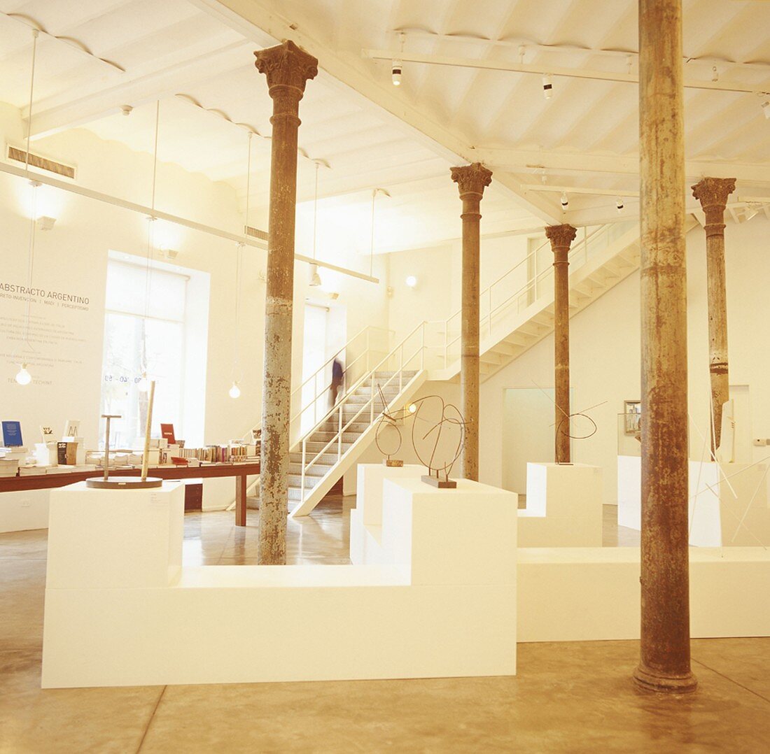 Ein Ausstellungsraum mit hoher Decke und antiken Säulen