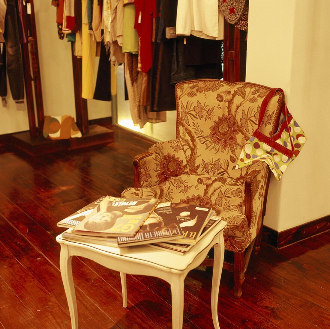 Sessel und Beistelltischen mit Zeitschriften in einem Modegeschäft