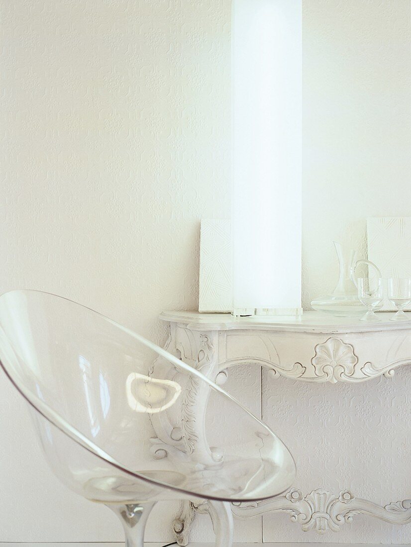 A transparent plastic chair in front of a lamp