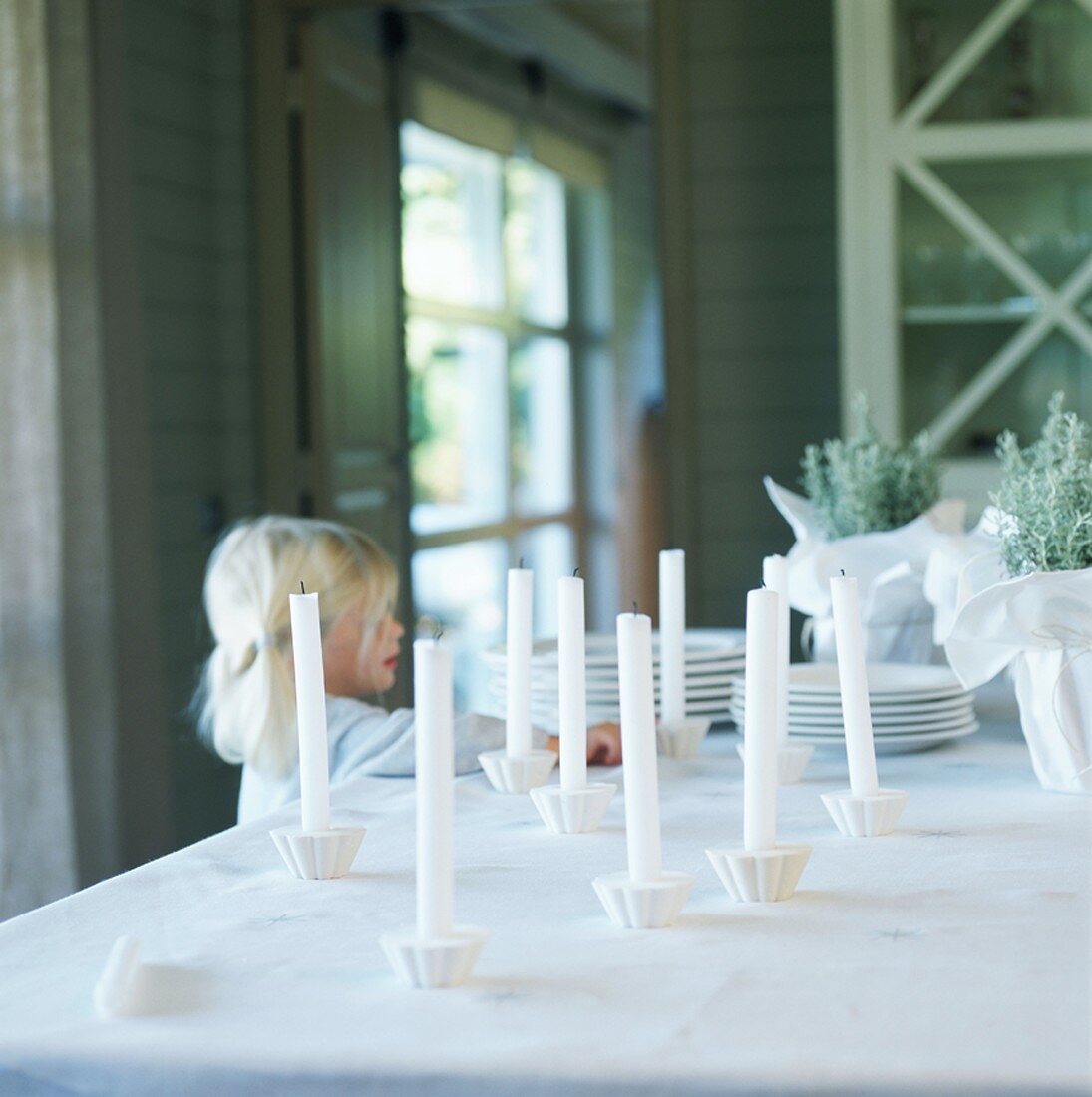 Mädchen dekoriert den Tisch mit Kerzen