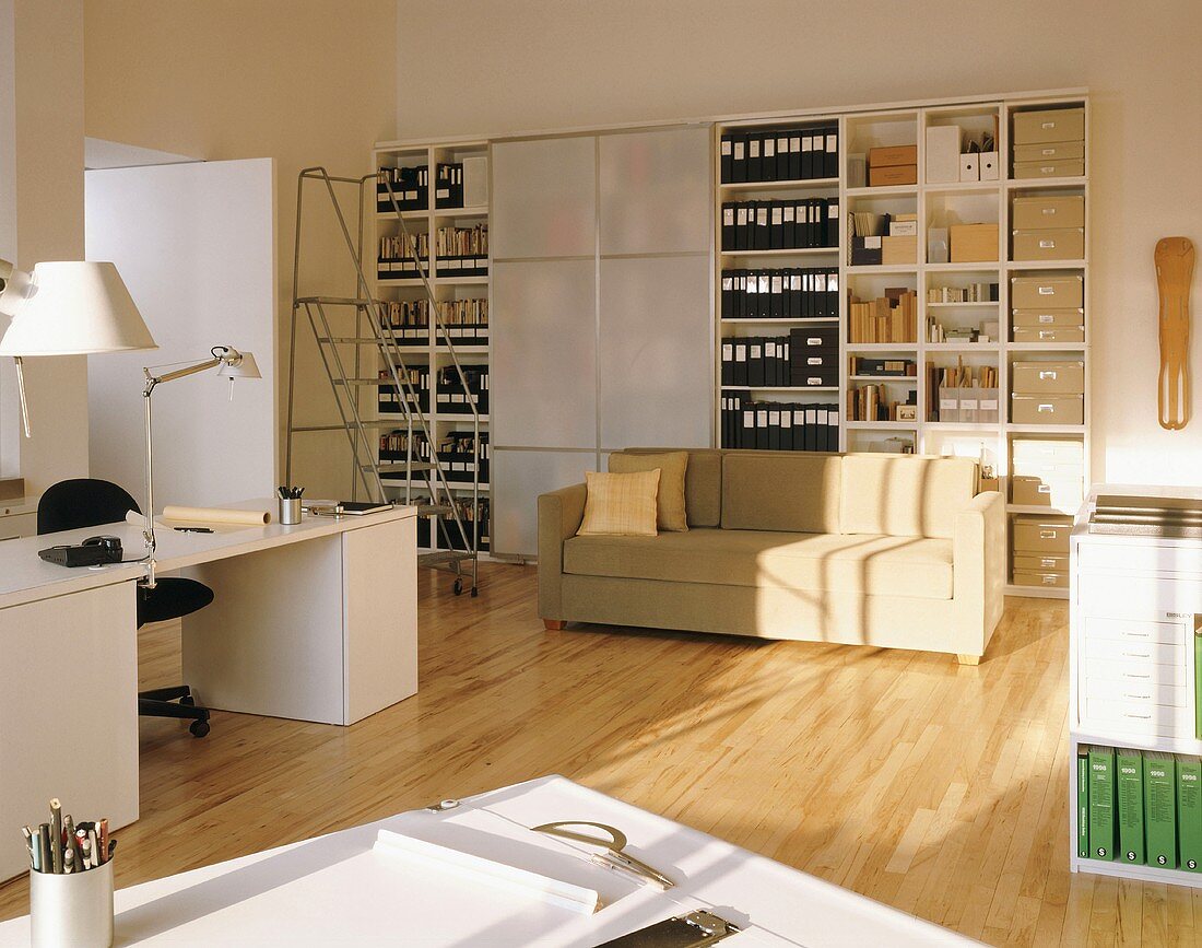 Großer Büroschrank mit Schiebetüren in einem großen Arbeitsraum mit Schreibtisch, Zeichentisch und Couch