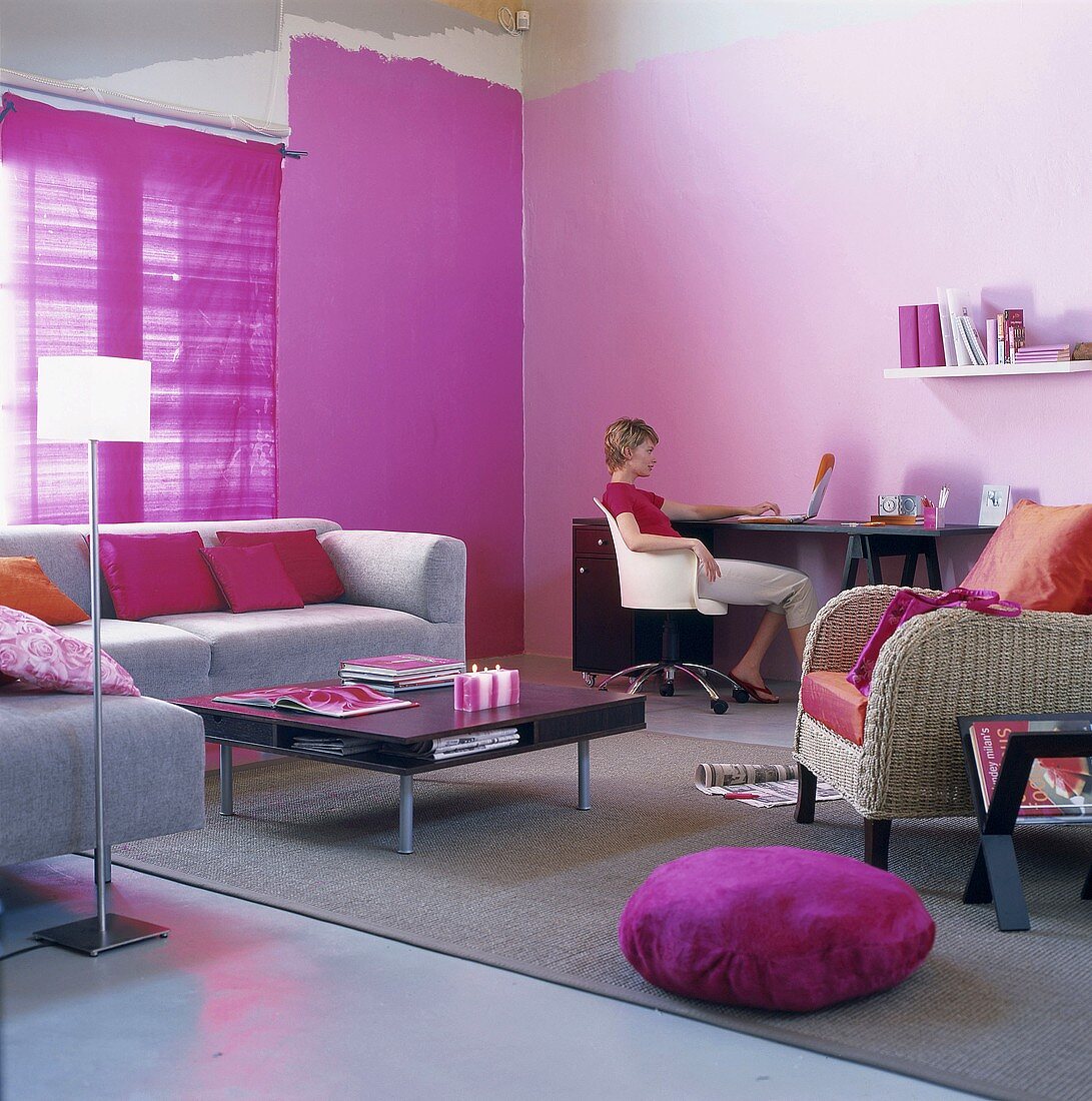Frau mit Laptop in grau-violettem Wohnzimmer