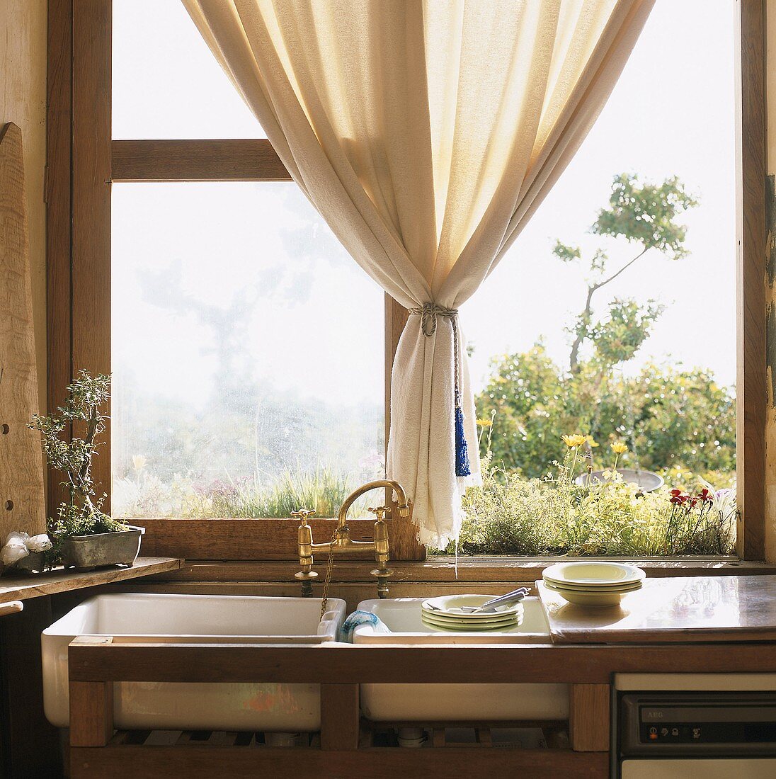 Spülbecken und Geschirr vor offenem Fenster