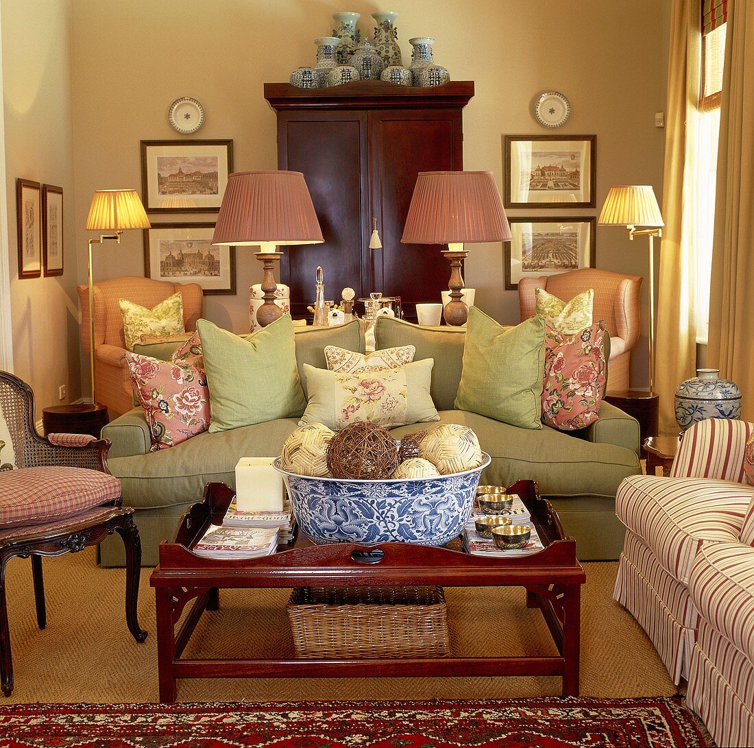 Symmetrisch eingerichtetes Wohnzimmer mit grüner Couch und und rosane Sessel im amerikanischen Stil