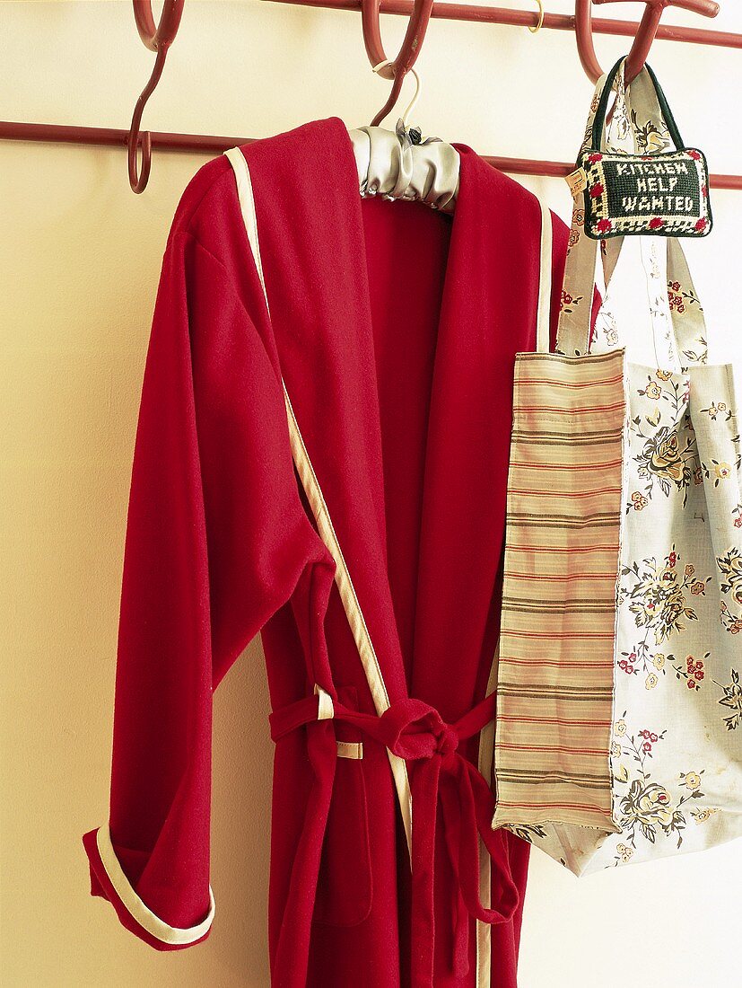 Roter Bademantel und Tasche mit Blumenmuster an der Garderobe