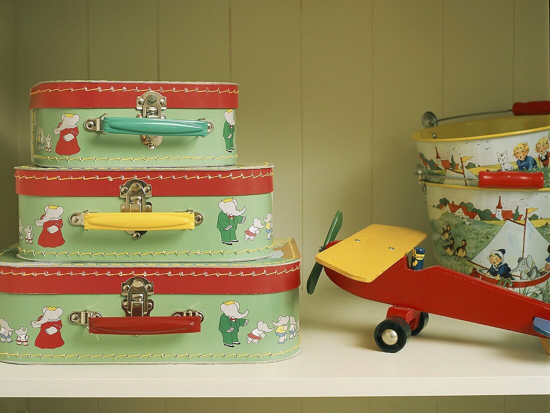 Children's suitcases and model plane on shelf