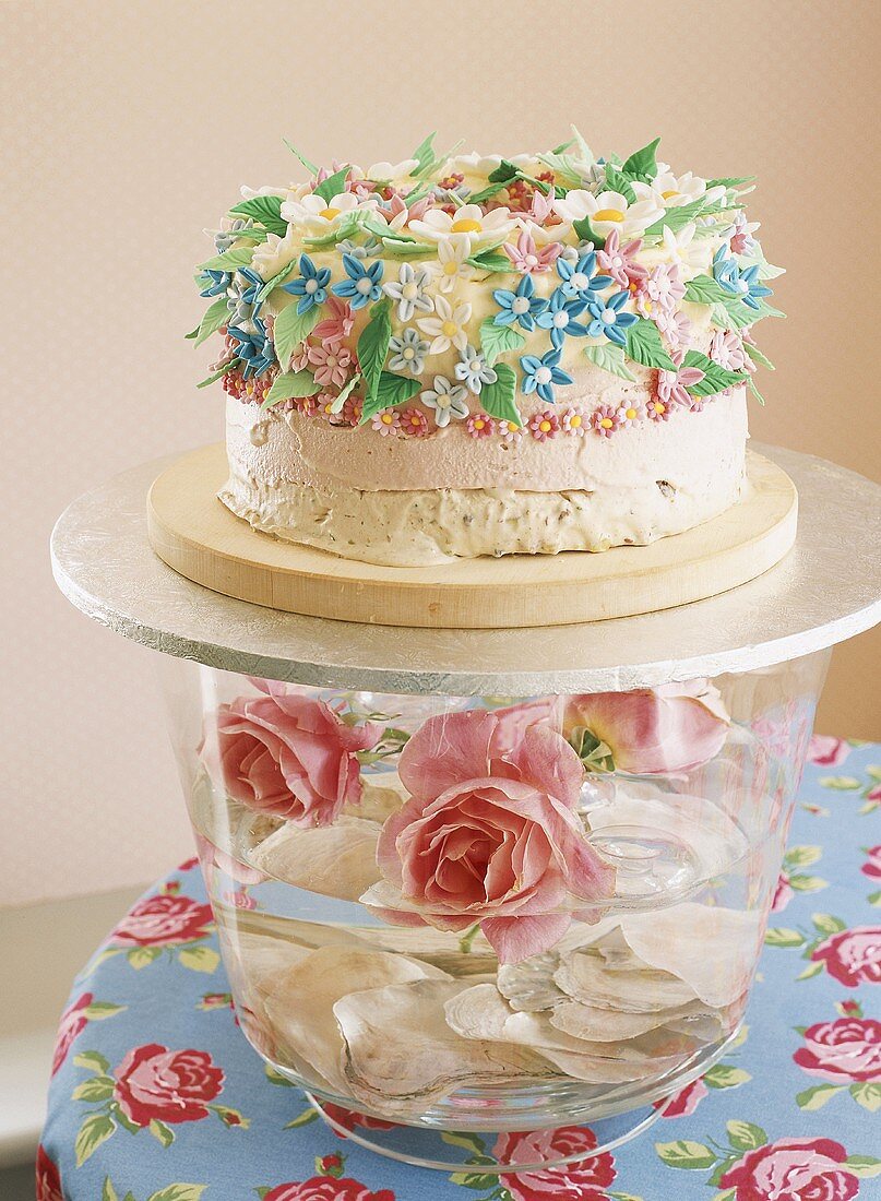 Glass bowl of roses with cake on top