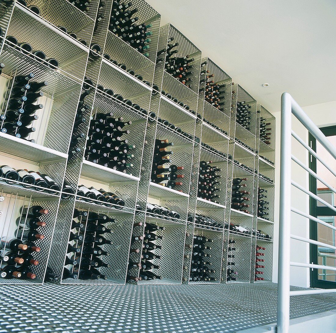 Gelagerte Weinflaschen in quadratische Metallregale auf einer Galerie