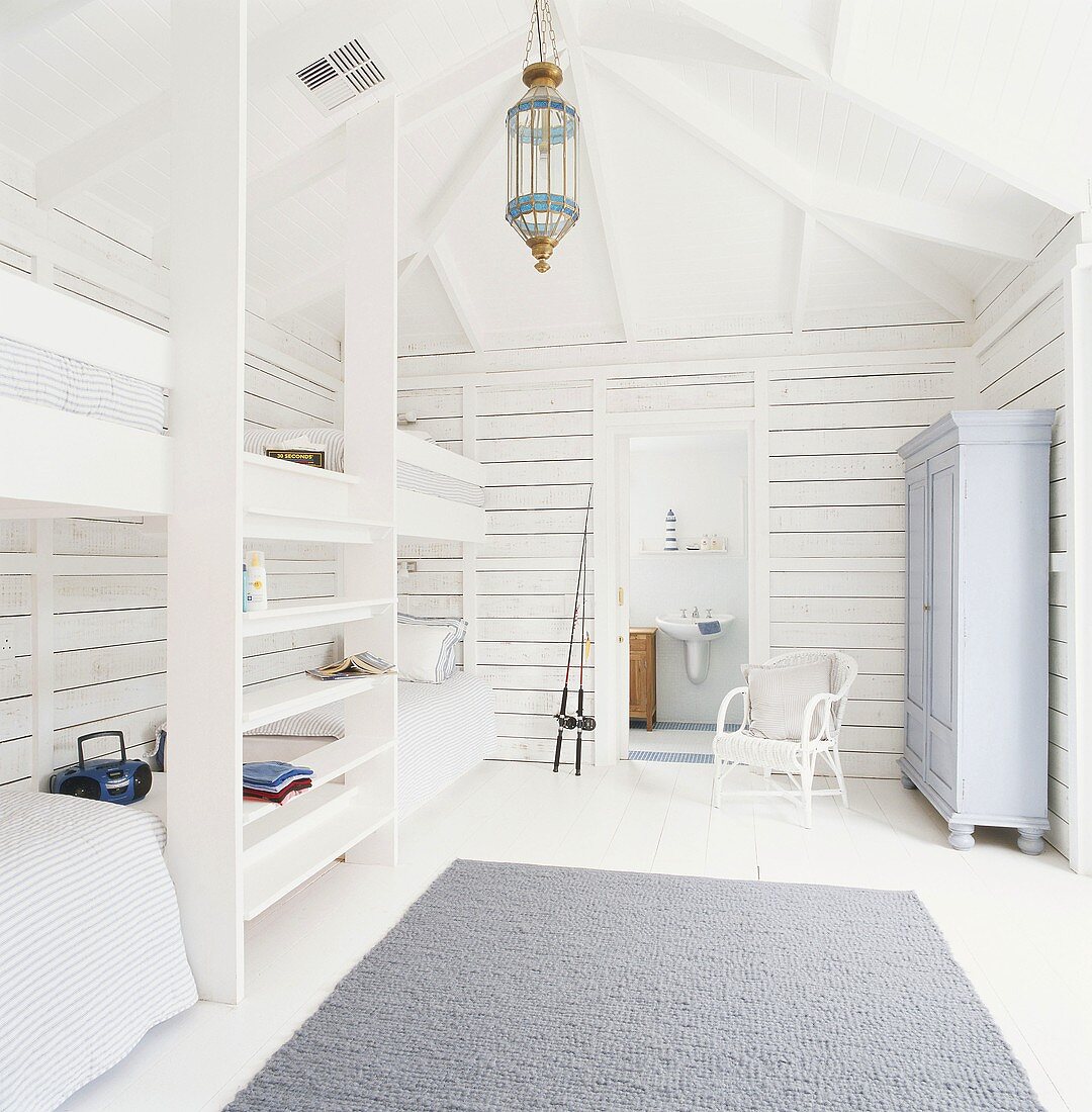 Kinderzimmer im weiß lackiertem Dachgeschoss mit Holzbalken und Hochbetten