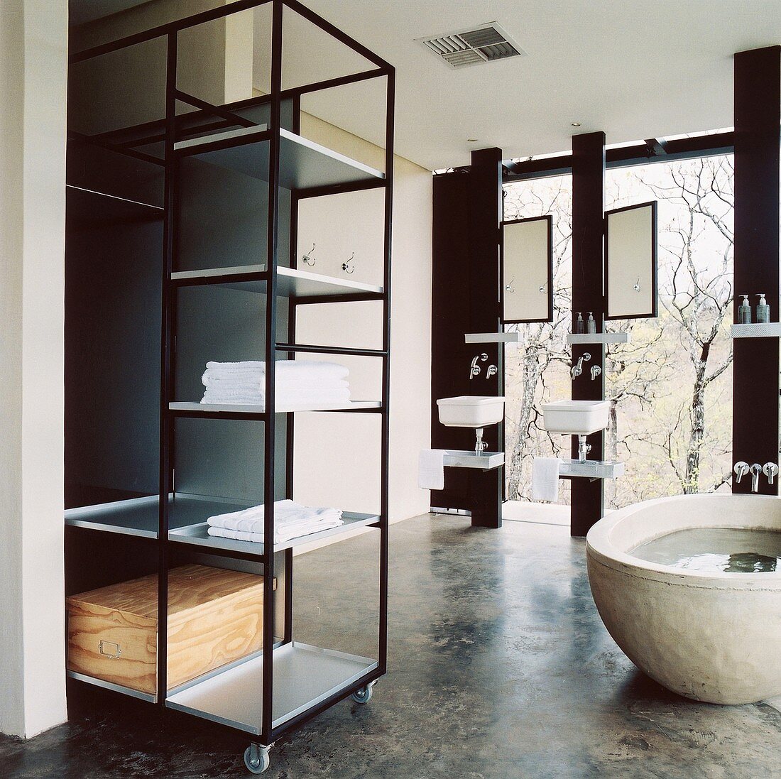 Badezimmer im Bauhaus-Stil mit freistehender Badewanne und Metallregal auf Rollen