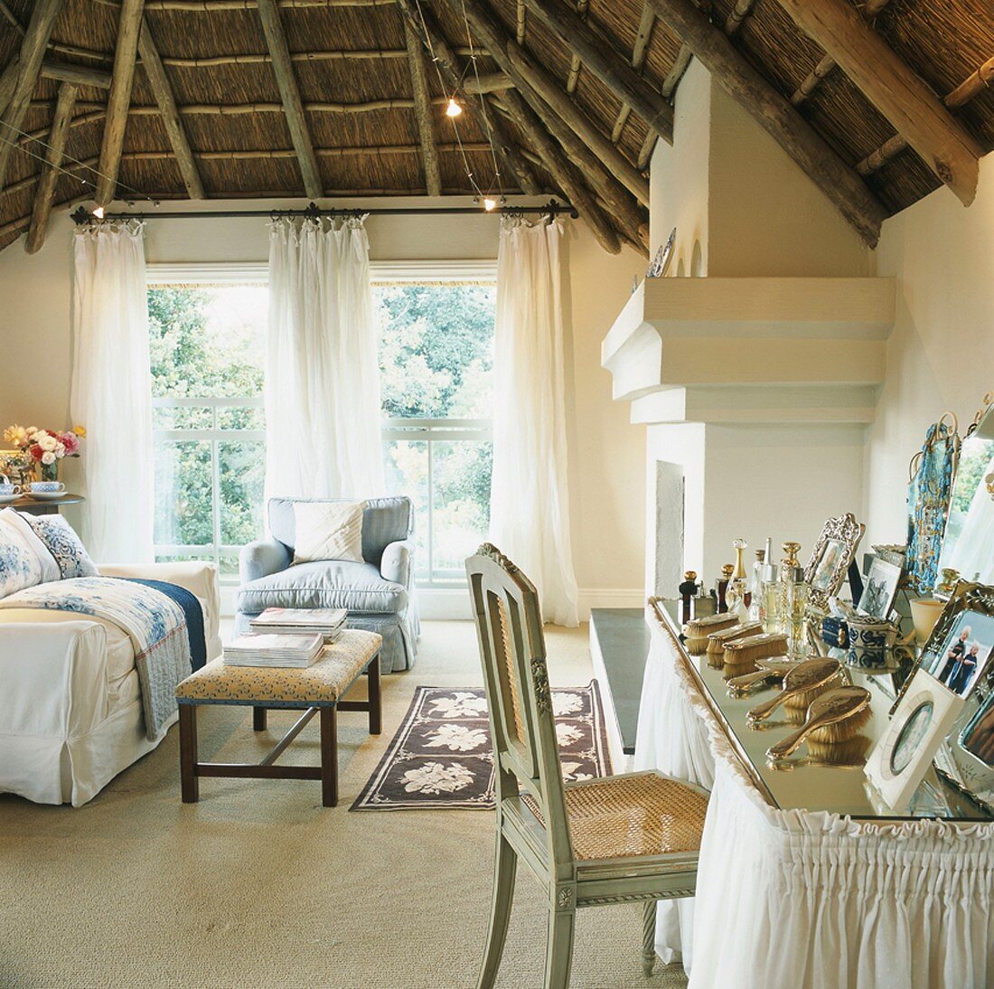 Die traditionelle Holzdecke bildet einen starken Kontrast zur eleganten Wohnzimmereinrichtung mit romantischem Schminktisch