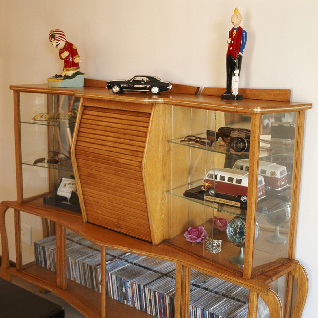 CDs & various ornaments in glass-fronted cabinet