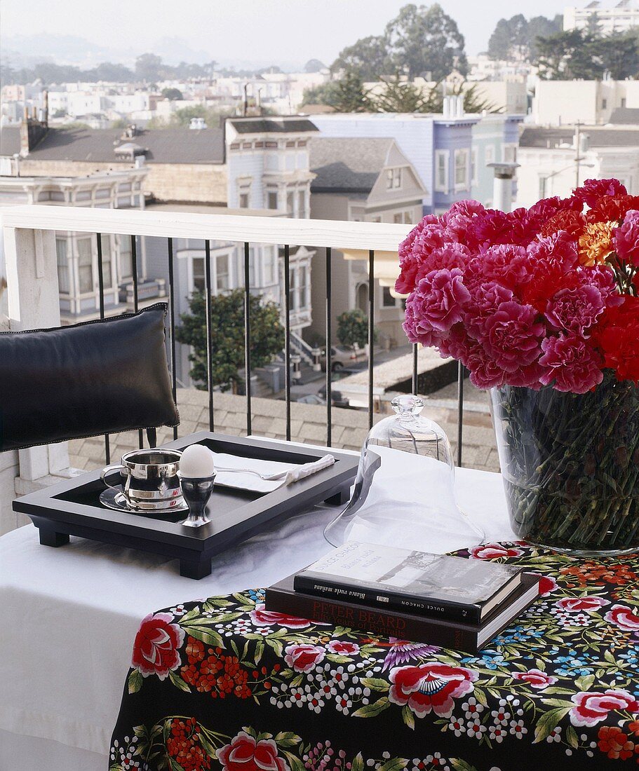 Blumen, Bücher & Frühstückstablett auf Balkontisch