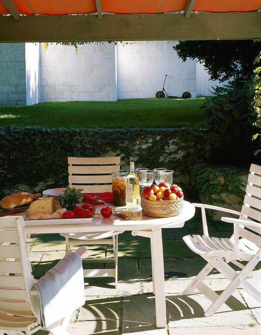 Fruits, vegetables and cheese on plastic table in the garden