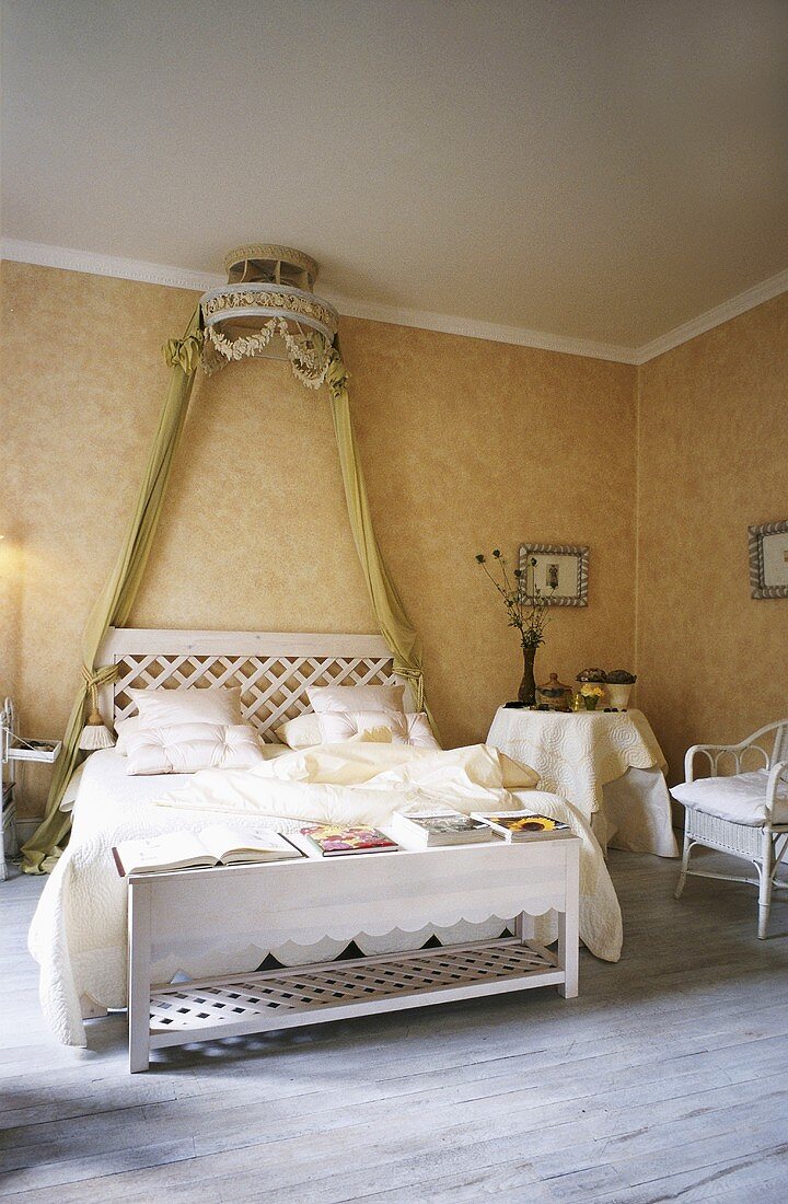 Doppelbett mit weiß lackiertes Holzgestell unter königliche Stoffhalterung an der Decke