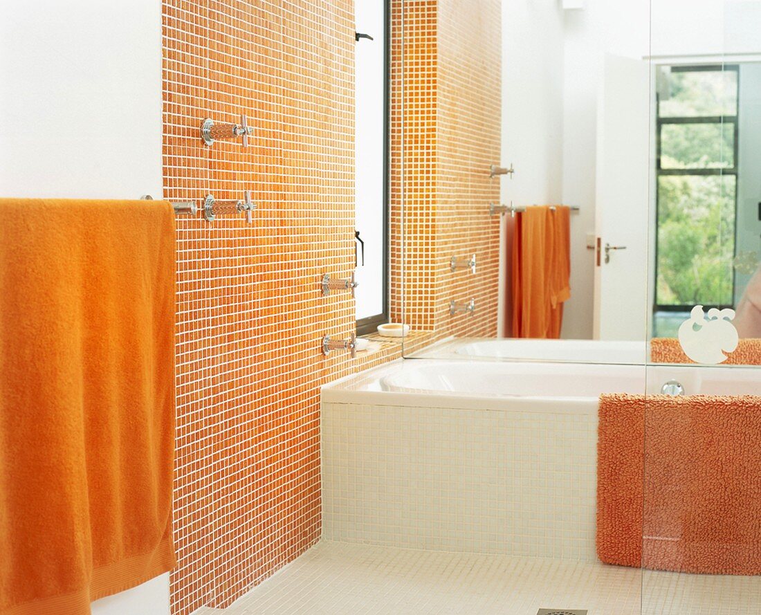 Badezimmer mit orangen Mosaikfliesen und Spiegelwand