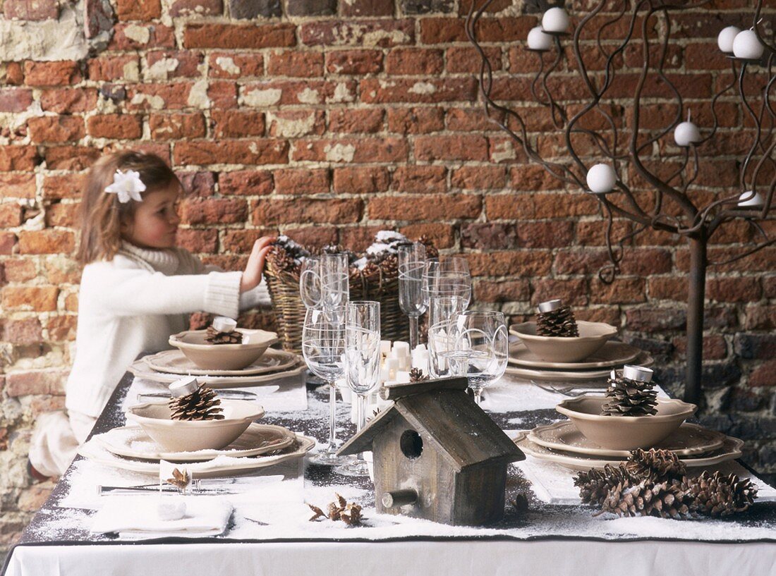 Mädchen am weihnachtlich gedeckten Tisch