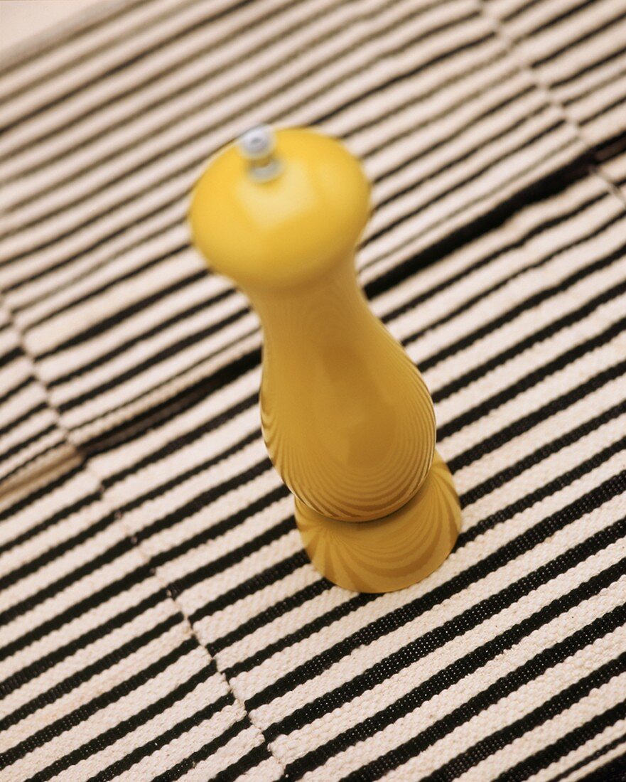 Pepper mill on striped surface
