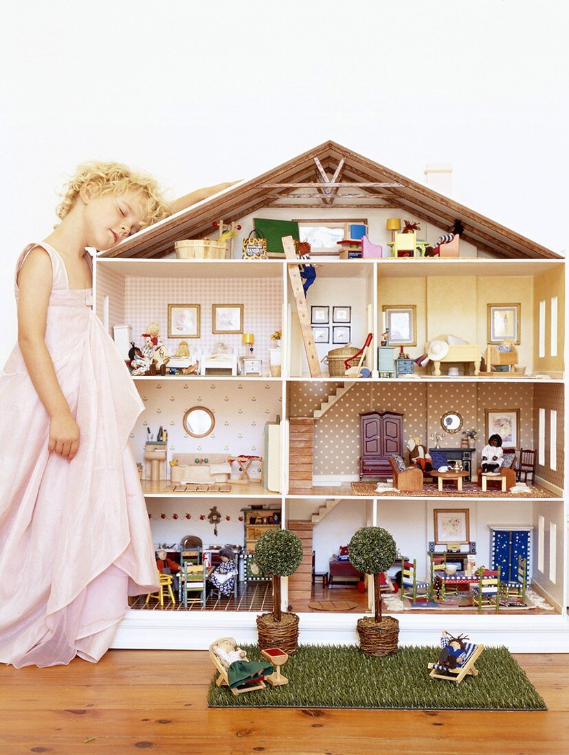 Girl leaning on dolls' house