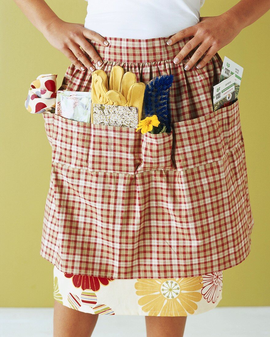 Woman with gardening tools in apron pockets