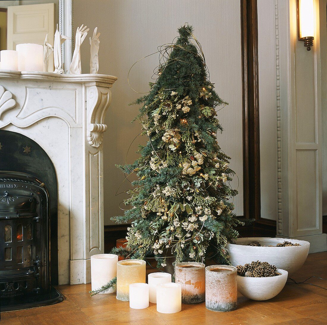 Christmas tree and rustic stump candles next to antique fireplace