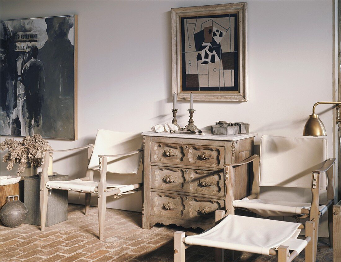Atelierstimmung mit einfachen, aber kunstvollen Holzmöbeln und modernen Bildern an der Wand