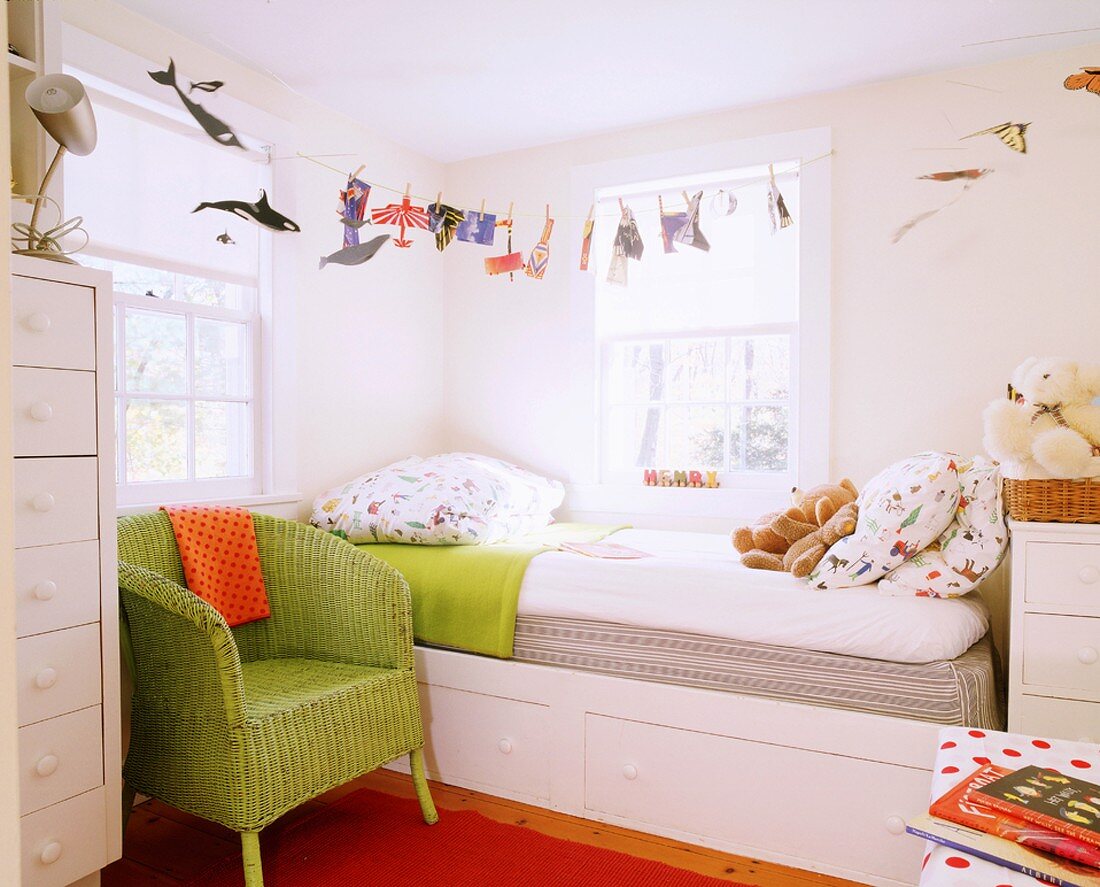 Kinderzimmer mit Bett in der Zimmerecke, lustiger Bettwäsche und leuchtenden Farbakzenten