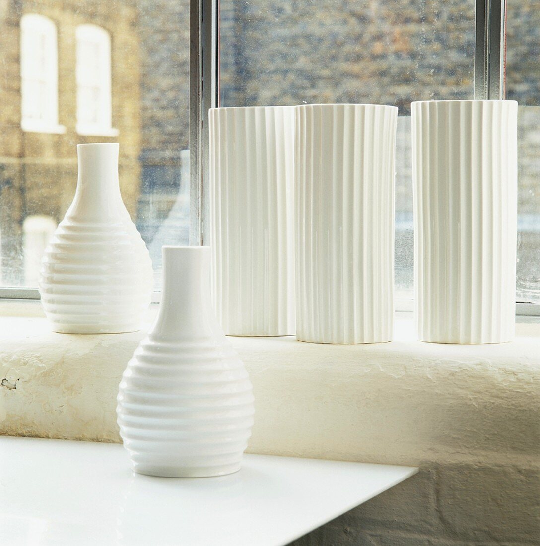 Still-life arrangement of vases in front of window