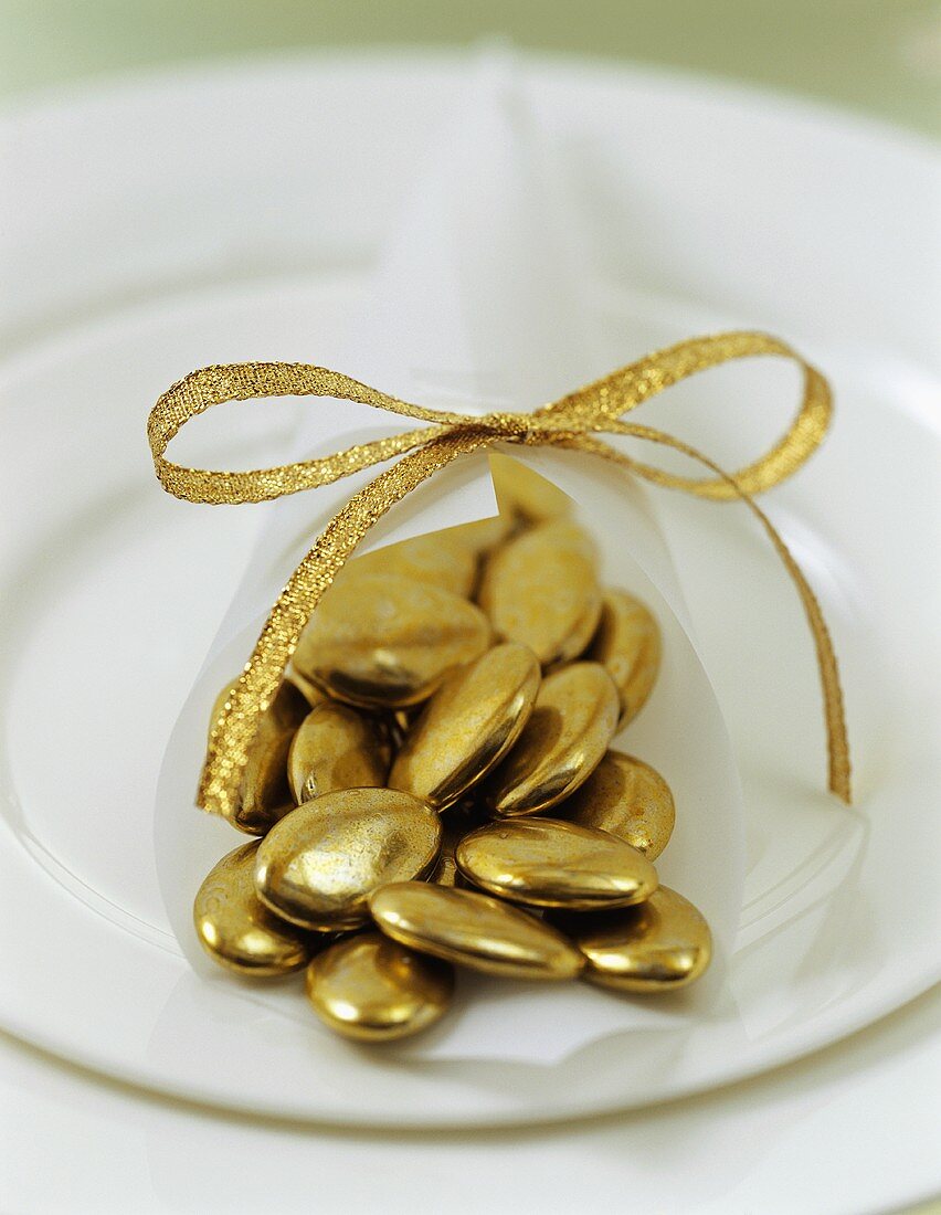 Goldene Schoko-Dragees als weihnachtliche Tischdeko