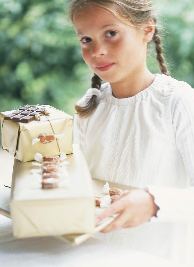 Kind hält Geschenke mit Süssigkeiten in den Händen