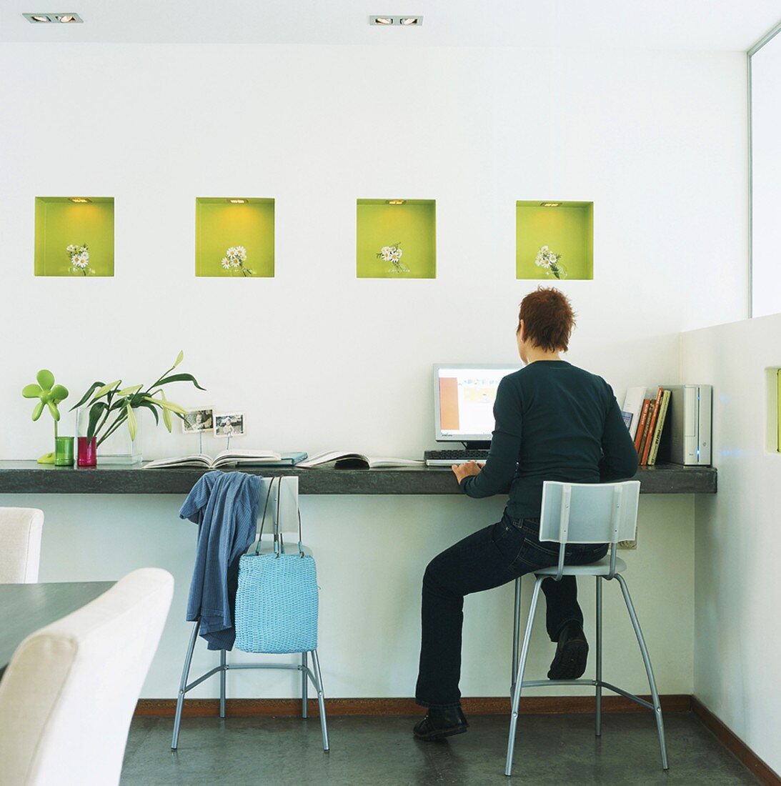 Woman sitting in front of computer on console table