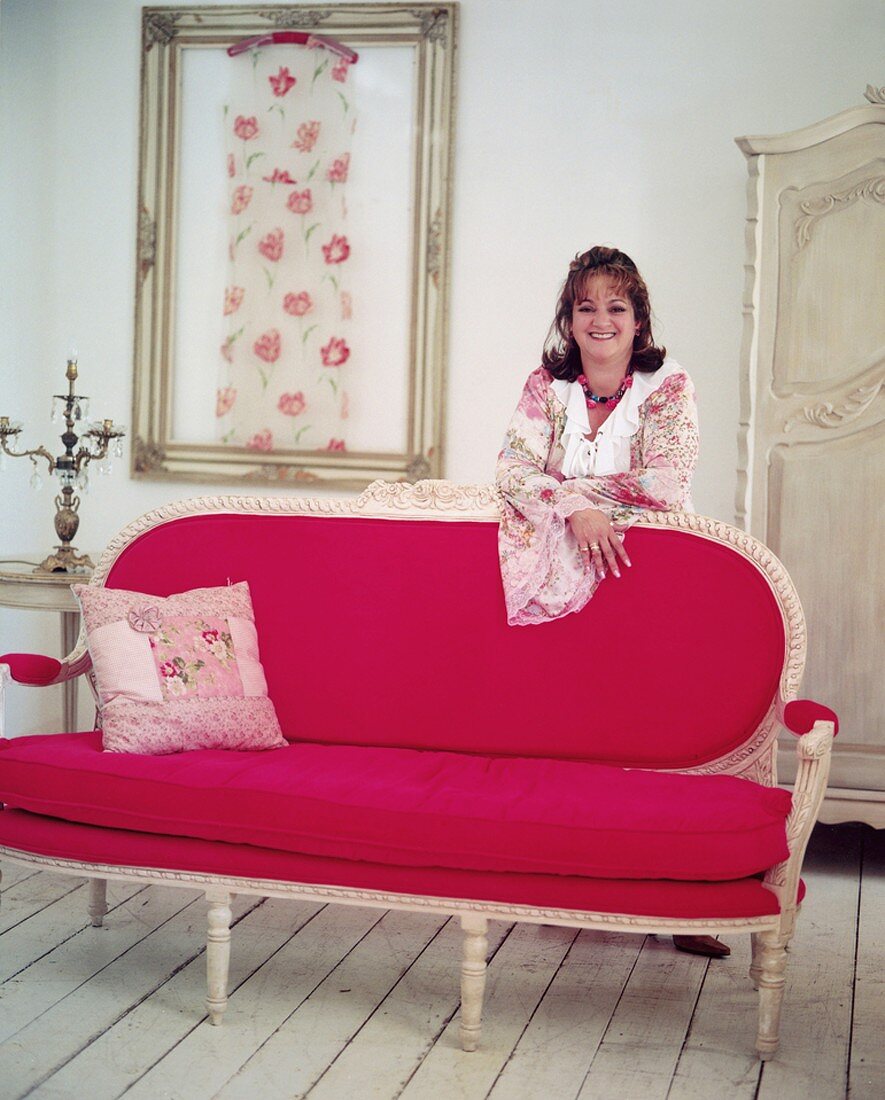 Woman leaning on pink sofa