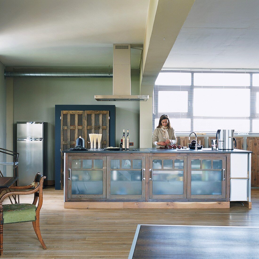 Woman standing next to kitchen counter in loft apartment kitchen-dining room