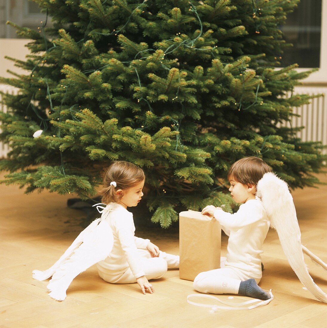 Mädchen und Junge packen Weihnachtsgeschenk aus
