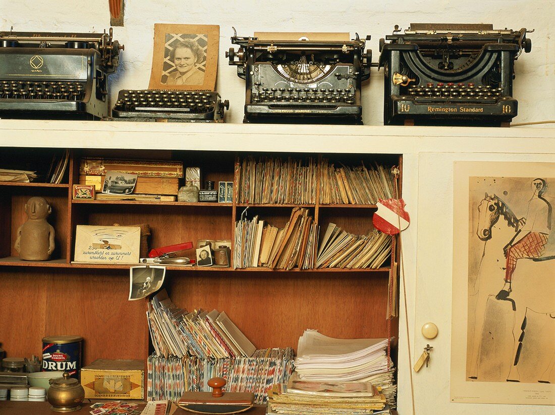 Alte Schreibmaschinen über einer sortierten Regalnische