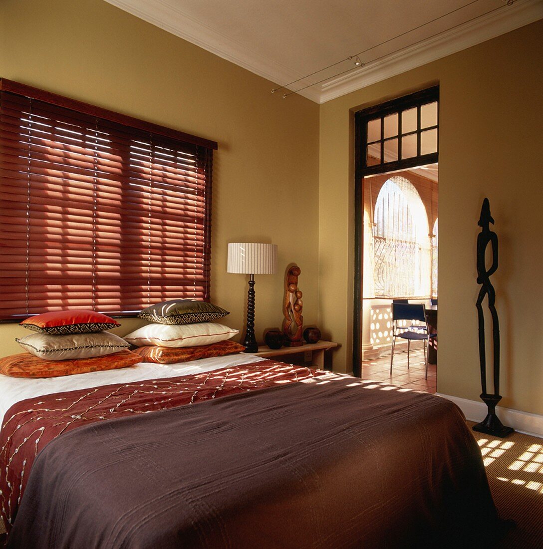 Einladendes Doppelbett in einem Schlafzimmer mit afrikanischem Flair