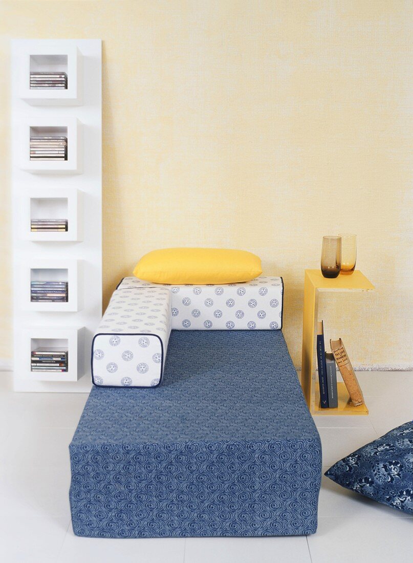 Moderne Schlafzimmerausstattung mit Regal, Beistelltisch und Bett in Gelb, Blau und Weiß