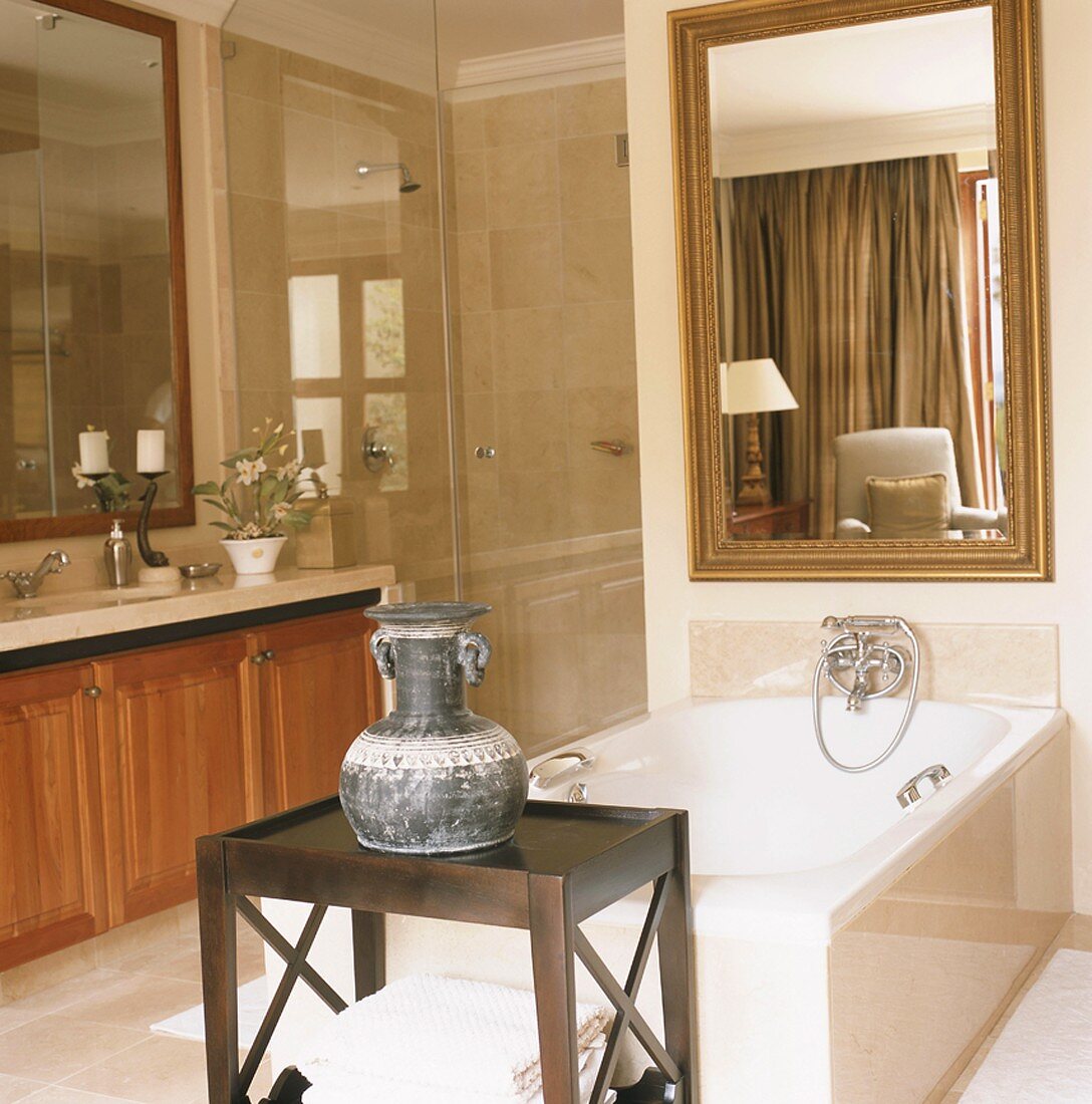 Einladendes Natursteinbadezimmer mit großem Barockspiegel über der Badewanne